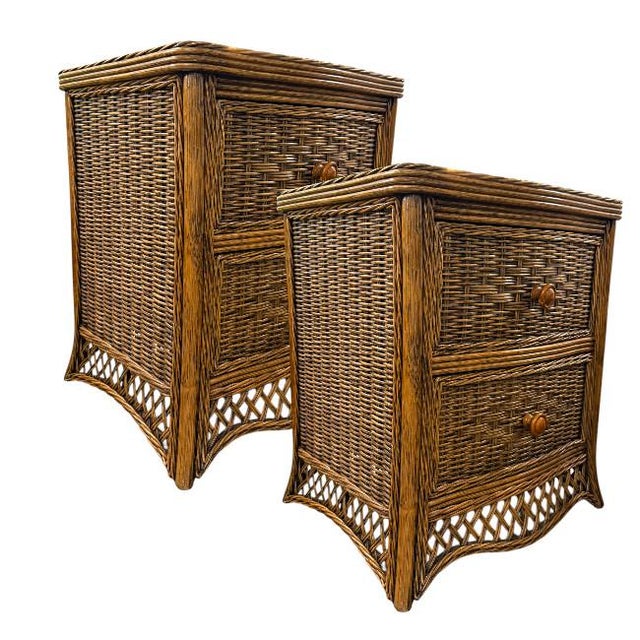 A pair of Tommy Bahama style woven rattan nightstands featuring a warm honey-brown finish and classic island-inspired...