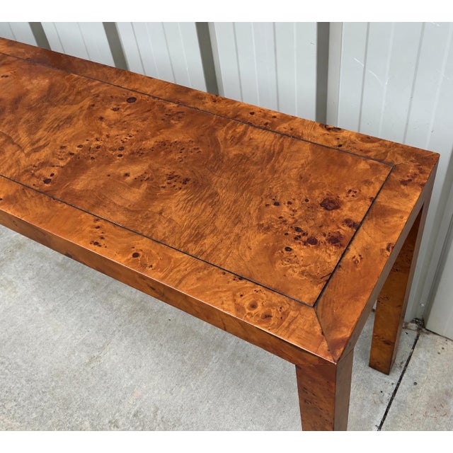 This is a 1970s Milo Baughman style burl olive wood Parsons style console table. The burl veneer highlights the wood grain...