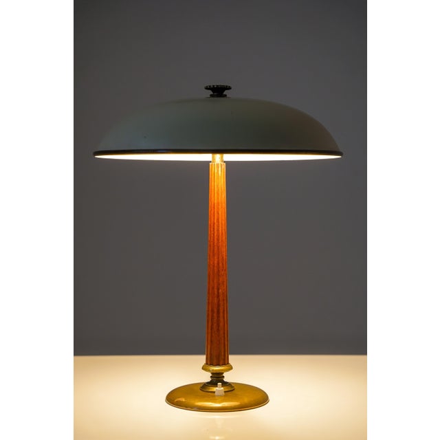 An elegant Swedish modern table lamp executed in mahogany and brass, designed by Erik Tidstrand for Nordiska Kompaniet....