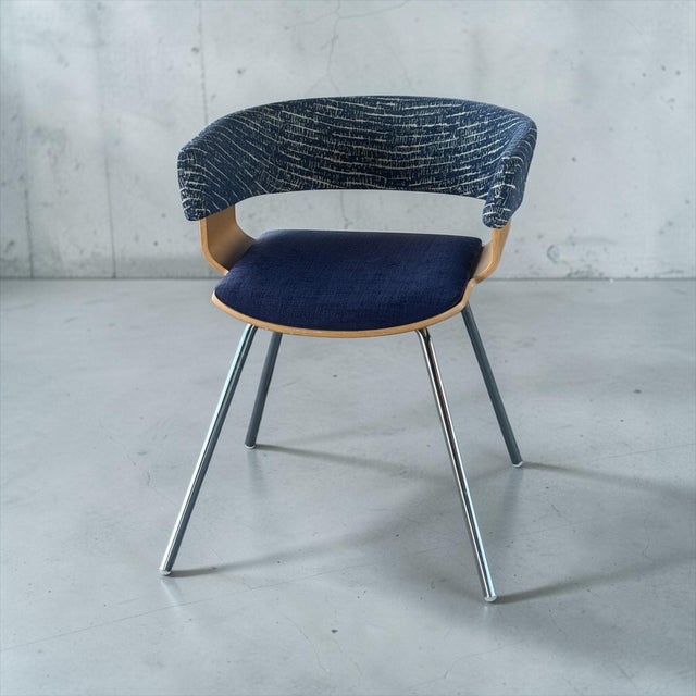 A distinctive Mollie A580 armchair by Allermuir, combining sculptural bent beech, polished chrome, and original two-tone...