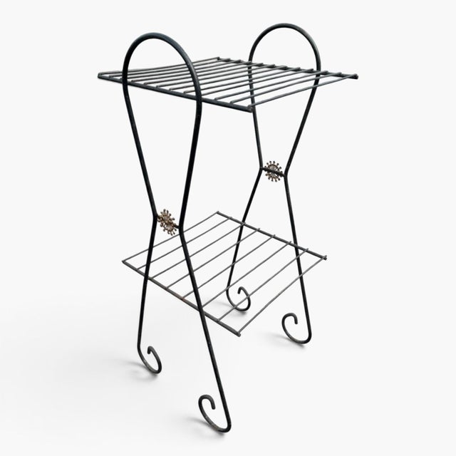 charming 1950s black wire metal plant stand featuring a two‑tier design and elegant scroll feet, perfect for adding...