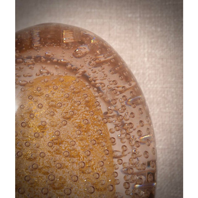 An egg-shaped sphere with internal decorations in multiple shades of gold and transparent. A sculpture of the highest...