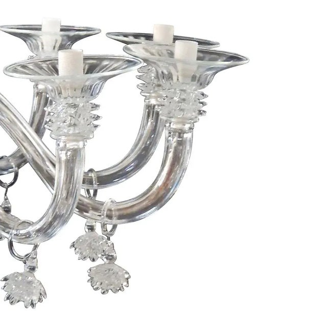 Venetian chandelier with a classic and worked design according to the renowned Murano glass technique. Forged and...