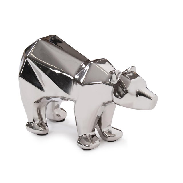 A modern sculptural interpretation of a polar bear is highlighted in an electroplated silver finish. The high polished...
