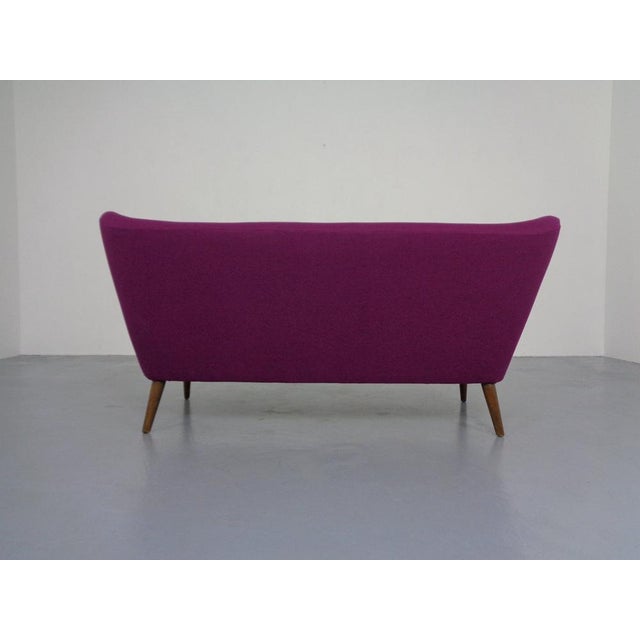 Completely reupholstered and repadded, organic cocktail sofa from the 1950s. Slightly splayed legs. The sofa can be placed...