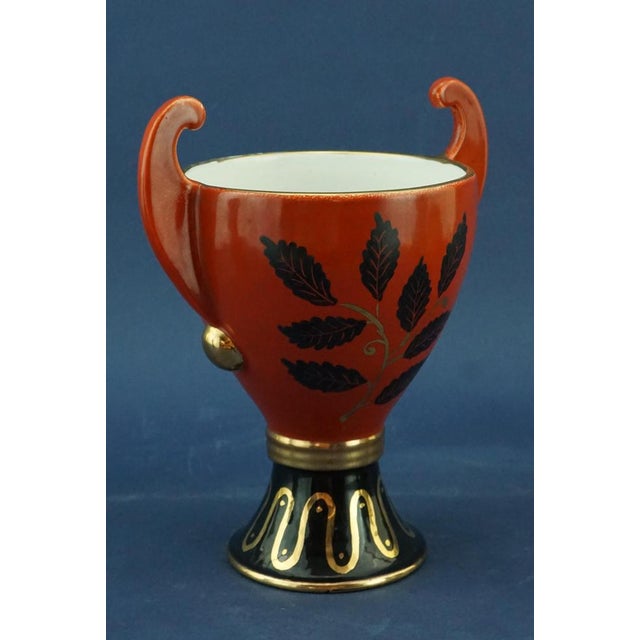 a stunning two-handled futurist-style ceramic vase, crafted from wheel-turned clay, glazed and entirely hand-decorated...