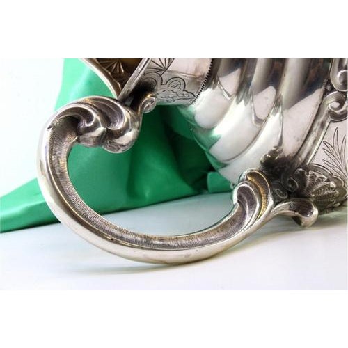 Flared Silver Water Jug with Monogram Plaque, Embossed Handle and Circular Base with Friezes, in Very Good conditions....