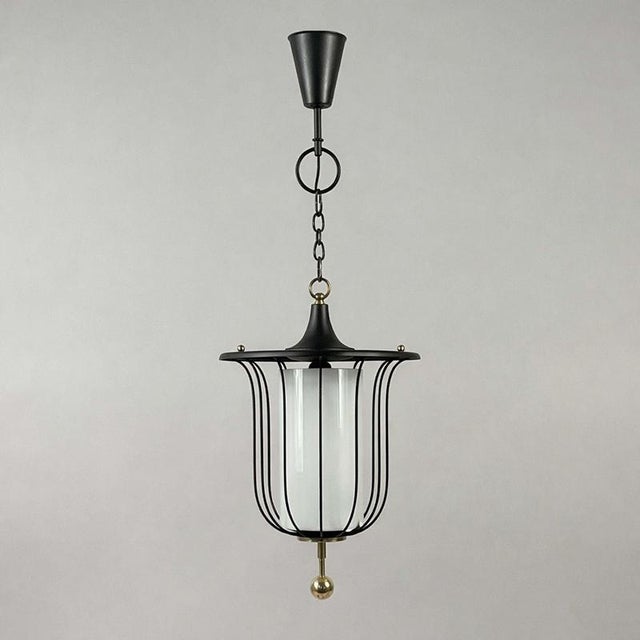 This mid-century pendant was designed and manufactured in France in the 1950s. The light features a lantern-shaped pendant...