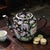 This Vintage Famille Noire Jingdezhen China Millefleur Painted Enamel Tea Pot is a collectible piece depicting Chinese...