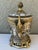 Vintage decorative urn made of porcelain with brass mounts. This ornate urn features a crackled white porcelain body with...