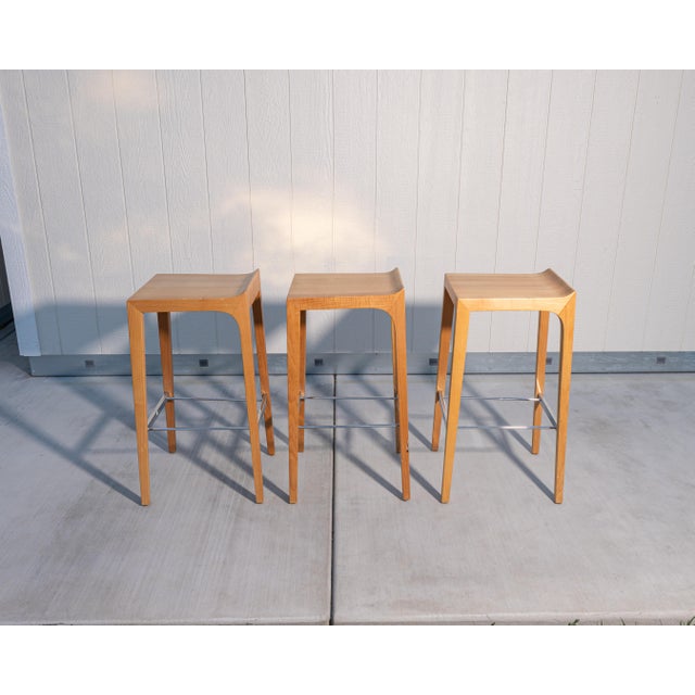 A set of three solid maple bar stools attributed to Bernhardt Design's Vanish collection. While unlabeled, their...
