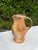 Vintage handcrafted studio pottery pitcher featuring a simple, organic form with a gently flared rim and elongated handle....
