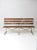 This vintage garden bench features a long, low profile with a timeworn presence, combining aged wood slats with a simple...