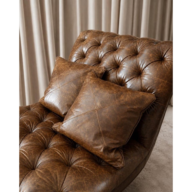 Striking vintage cognac brown leather chaise lounge with deep button tufting, a sweeping Chesterfield-inspired profile,...