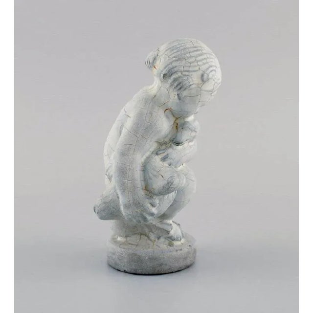 This is a decorative stone figure from Kähler, Denmark. The figure in glazed stoneware of Leda and the swan. It is made...