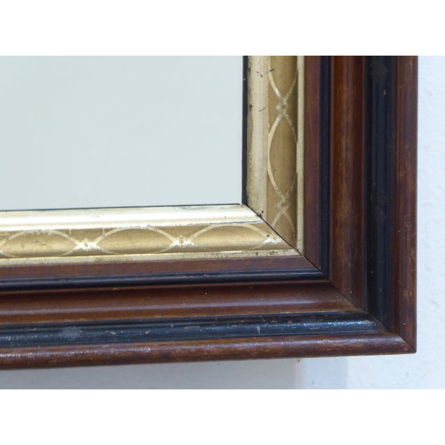 This walnut mirror has a stenciled gold leaf liner and measures 21.75"H x 18.25"W.