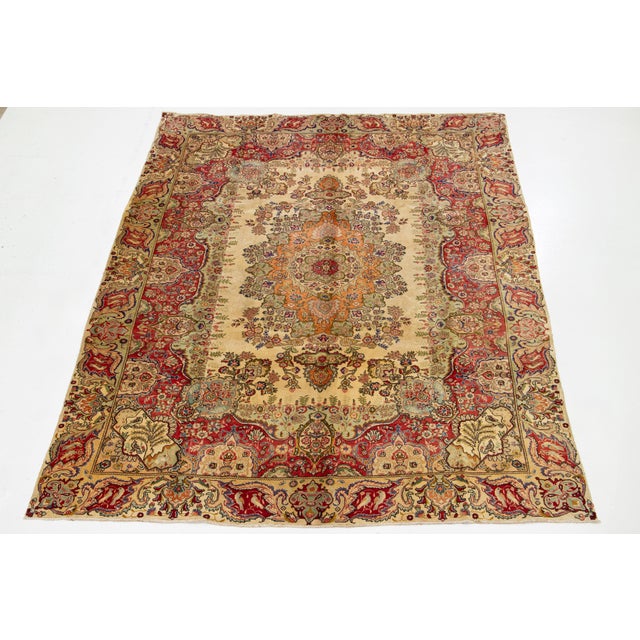 This vintage 1930s tan handcrafted Persian wool rug features a rosette motif with multicolor accents throughout the...