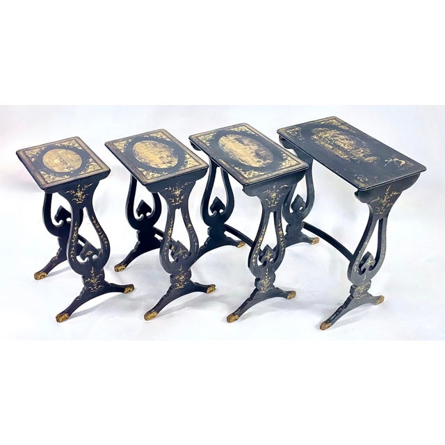 Antique set of four Chinoiserie nesting tables. Various gilt Asian scenes hand-painted on each table top surrounded by...