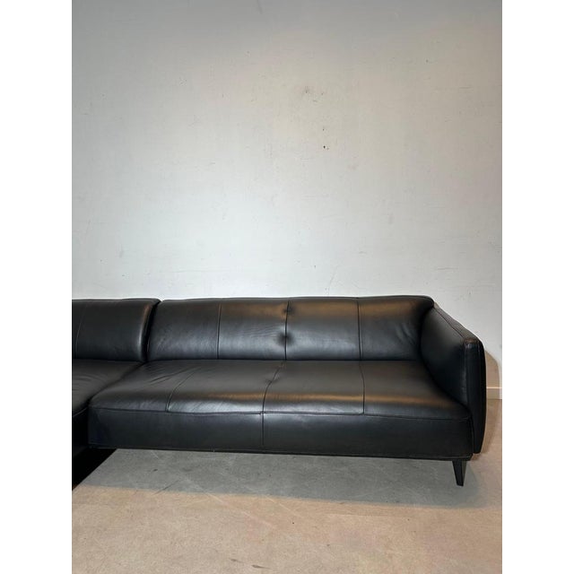 Elegant and contemporary corner sofa by BoConcept, upholstered in high-quality black leather. This model features a...