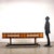 Store bench with enamelled metal base, wooden lists and adjustable brass feet, flat with open compartment and drawer on...