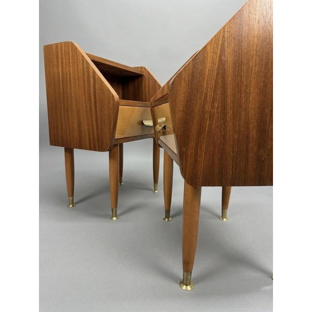 Enhance your bedroom with this exceptional pair of authentic 1950s Italian nightstands featuring rich teak veneering and...