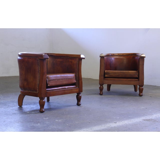 Early 1900s club chairs in thick, high-quality leather – pure Gatsby style. Elegant curved armrests with refined detailing...
