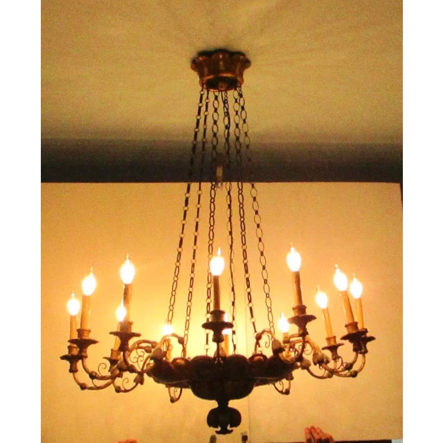 Large carved wooden Belle Epoche gilt and painted chandelier. 12 arms mounted to a suspended central bowl with floral...