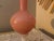 A striking vintage decorative glass vase featuring a rich, opaque rose-pink body, an elegantly elongated trumpet neck and...