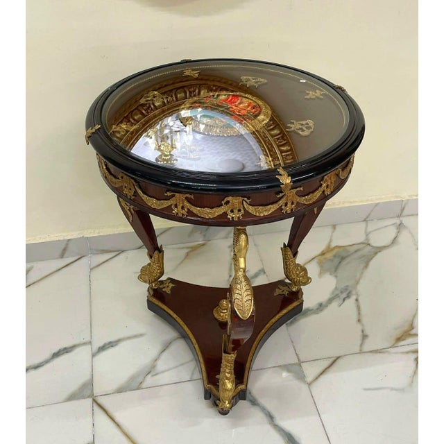 This elegant French-style wood side table features a refined design enhanced with luxurious gold leaf detailing and...