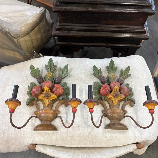 A pair of late 20th Century Spanish wall sconces. These hand-carved and painted sconces are simple yet bursting with joy...