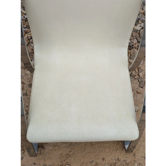 This is an off white leather rocking chair. It has chrome arms. It is sturdy. This would look great in a contemporary...