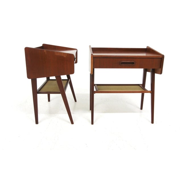 Pair of bedside tables, Swedish design, 1960s. Teak veneer frame with contoured sides and a raised back edge. Each unit...