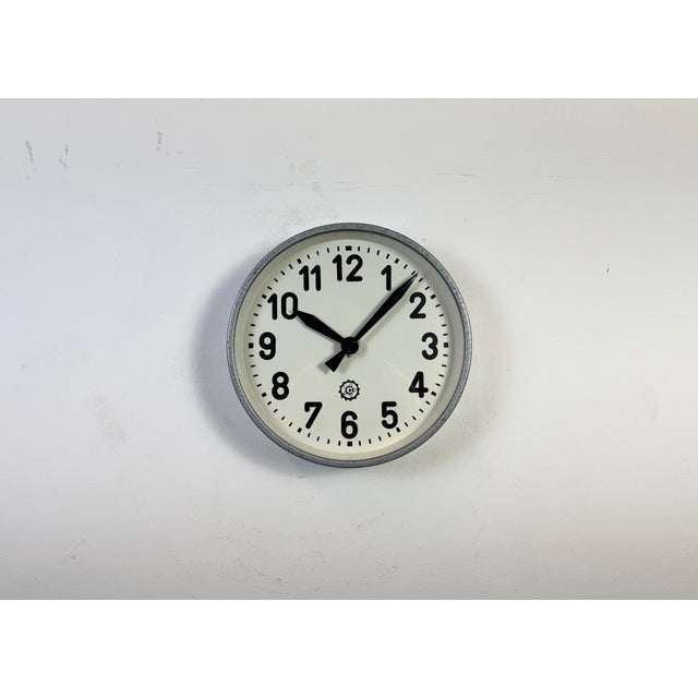 This wall clock was produced by Chronotechna in former Czechoslovakia during the 1950s. It features a grey hammer paint...