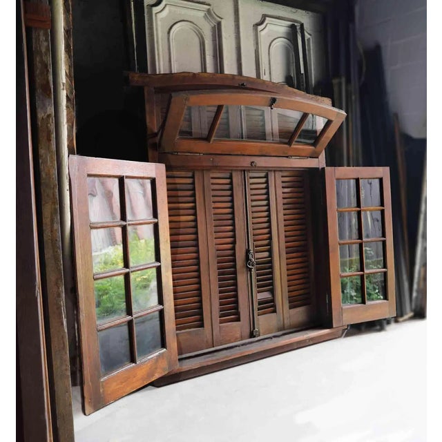 Complete antique Italian window unit made out of a mahogany like wood of it’s day. It features an operating transom on...