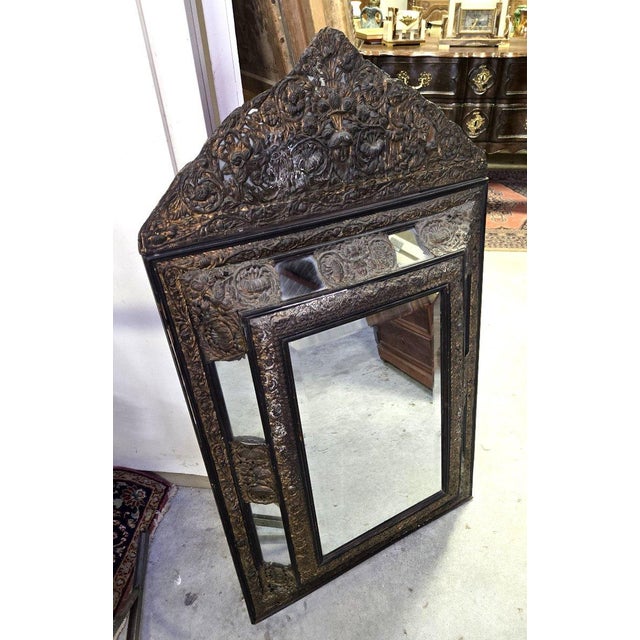 Antique repoussé copper mirror with a carved pediment, showcasing exceptional craftsmanship. The frame is entirely adorned...