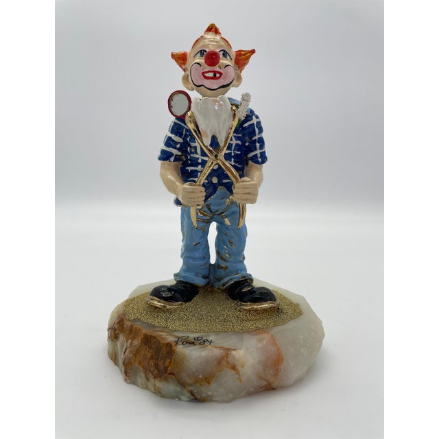 Celebrate the whimsical artistry of acclaimed American sculptor Ron Lee with this signed 1984 Dentist Clown sculpture, an...