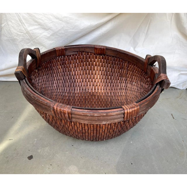 Vintage Asian Woven Willow Gathering Basket. Dark brown in color with wood handles and wood trim. I have more sized in my...