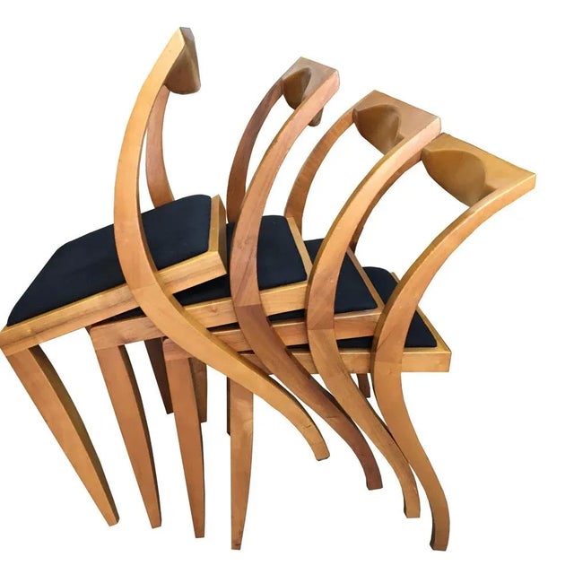 4 dining room chairs made of light walnut wood with black cotton cover. These are carpentry work, possibly objects of a...