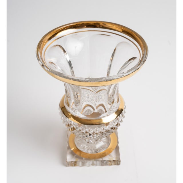 A handsome cut crystal vase in classic urn form, featuring a flared, scalloped rim edged in gold, a diamond-cut lower body...