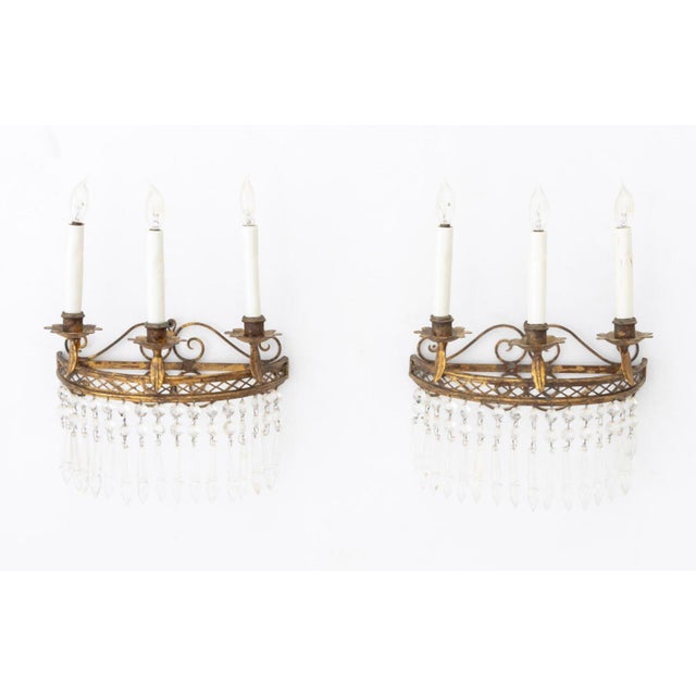 Pair of French Empire Style Gilt Wrought Iron Three-Branch Wall Sconces, each with pierced scroll form back plate and drop...