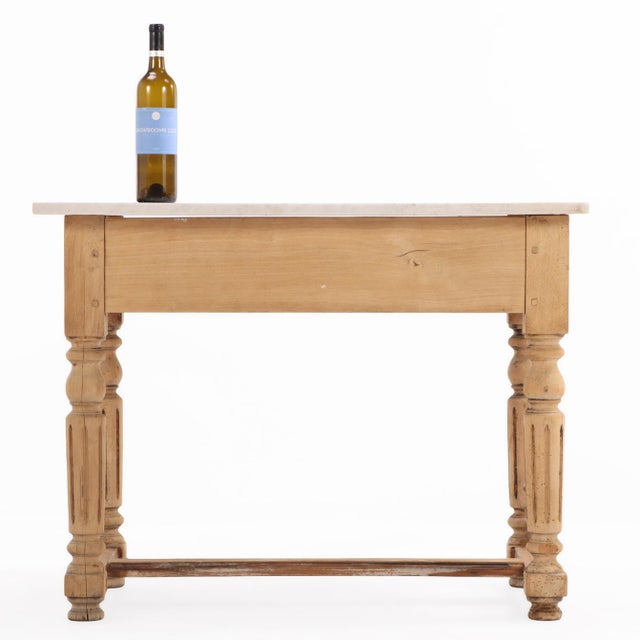 This table has a wonderful neutral appearance with a white marble top over a base with pegged construction including a...