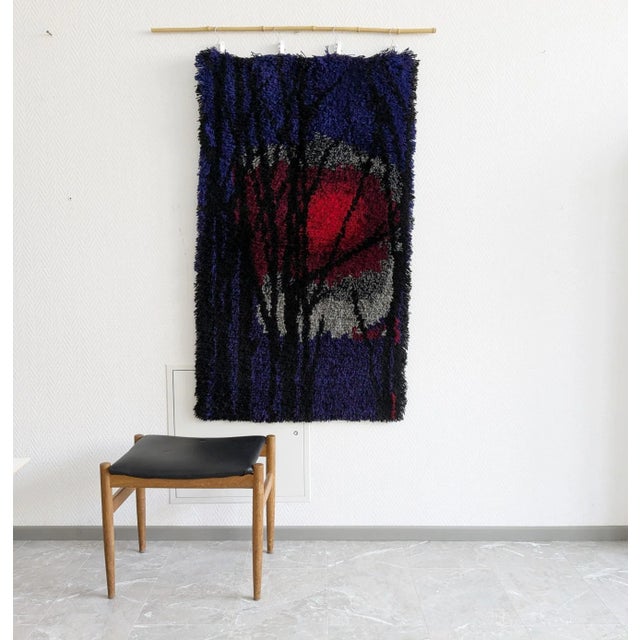 This rug from the 1960s / 1970s is a hand-knotted rug made of sheep's wool. The wool rug in strong purple shows a red sun...