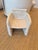 A ceramic sculpture of a chair. Made of clay and is glazed in a natural white. The finish has some texture which gives it...