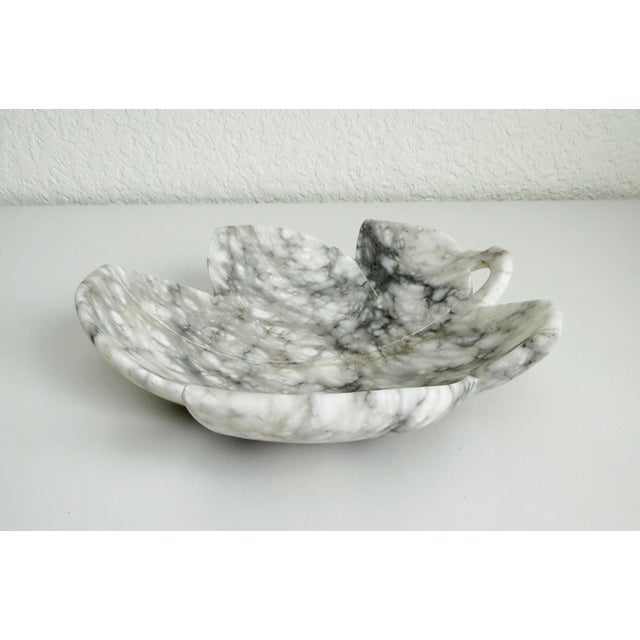 Vintage 9" wide shallow bowl crafted in Italy, circa 1950s. Made of carved alabaster formed in a stylized leaf shape. The...