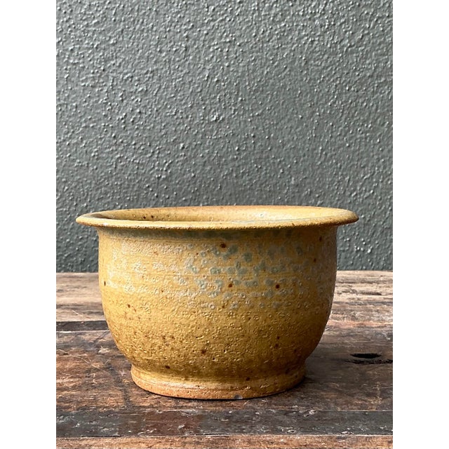 This vintage studio pottery bowl is a charming example of 1970s artisanal ceramic work, blending organic textures with a...