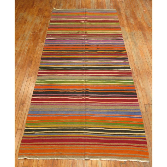Mid-20th century hand knotted one of a kind Turkish Kilim with a brightly colored striped design. Measures: 5'3" x 13'5".