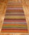 Mid-20th century hand knotted one of a kind Turkish Kilim with a brightly colored striped design. Measures: 5'3" x 13'5".