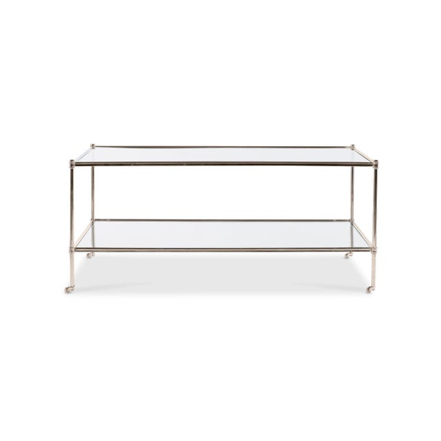 Refined nickel cocktail table with small, elegant casters and tempered glass shelves. Polished finish.