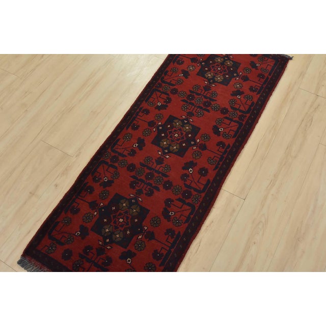 A tribal Turkmen runner hand-knotted with an all-wool pile on a wool foundation. This oriental rug features a row of...