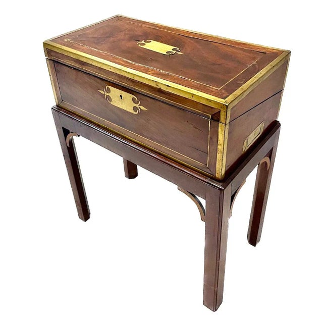 Antique portable campaign writing desk with hinged top to open as a desk surface. Fabric writing surface has leather hinge...